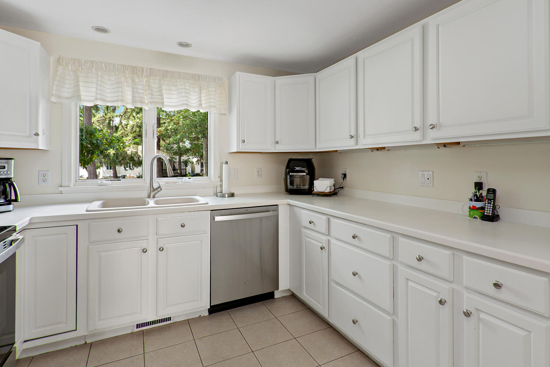 5 Friendship Court Mashpee, MA 02649 - Photo 9 of 32 a kitchen with white cabinets appliances a sink and a window