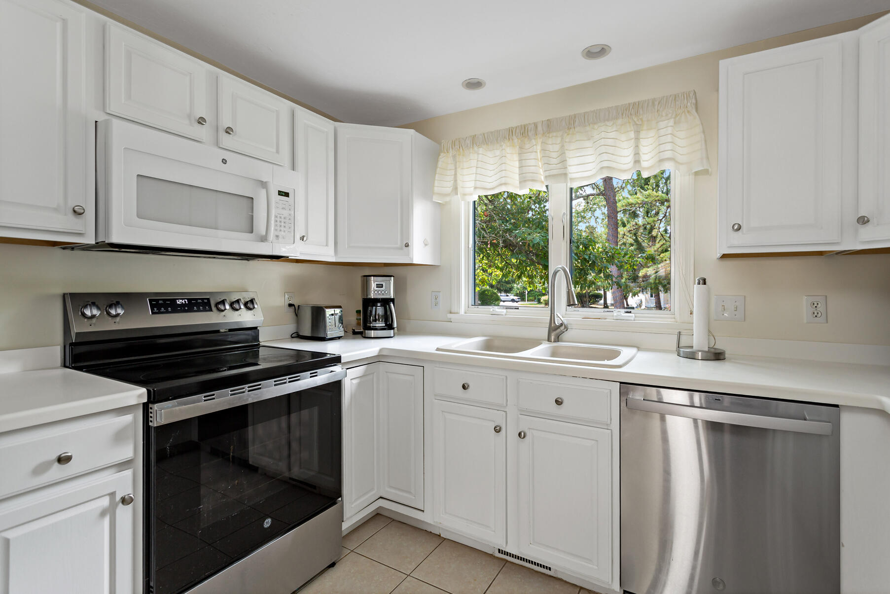 5 Friendship Court Mashpee, MA 02649 - Photo 10 of 32 a kitchen with white cabinets appliances and a window