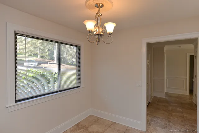 a view of a livingroom with a chandelier fan and wooden floor