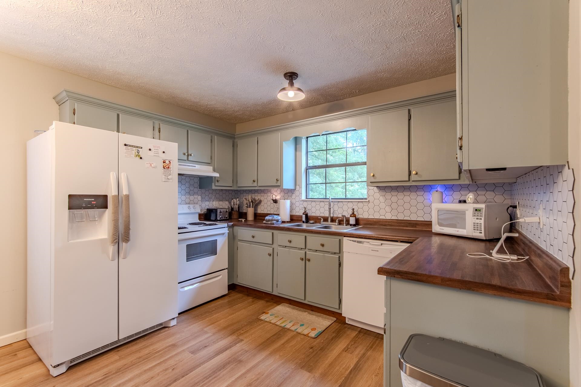 15 Lilly Cove Counce, TN 38326 - Photo 8 of 39 a kitchen with granite countertop a refrigerator stove sink and cabinets