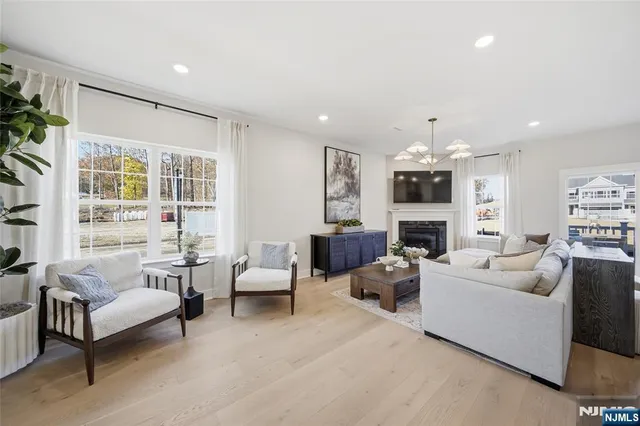 a living room with fireplace furniture and a large window