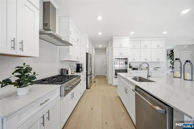 a large kitchen with stainless steel appliances granite countertop a lot of counter space and a sink