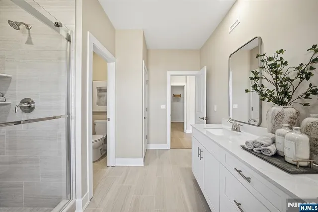 a large white bathroom with a granite countertop sink a mirror and shower