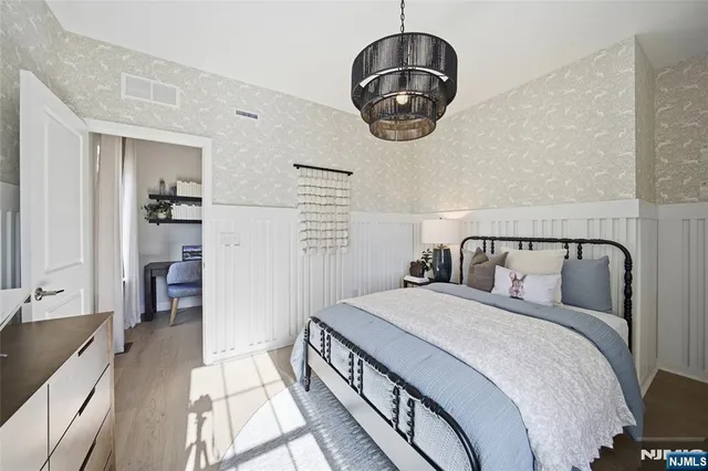 a bedroom with bed and a chandelier