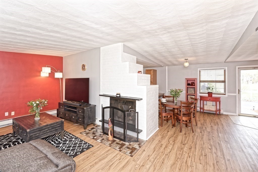 54 Gregory Road Framingham, MA 01701 - Photo 14 of 41 a living room with furniture a fireplace and a flat screen tv