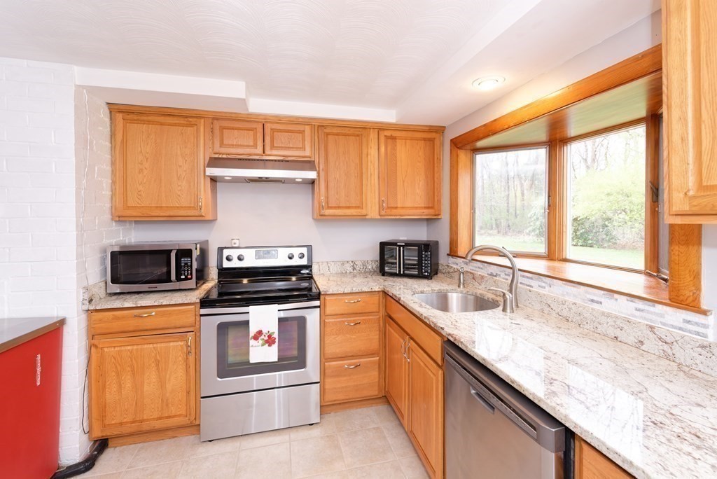 54 Gregory Road Framingham, MA 01701 - Photo 19 of 41 a kitchen with granite countertop a sink stainless steel appliances and a window