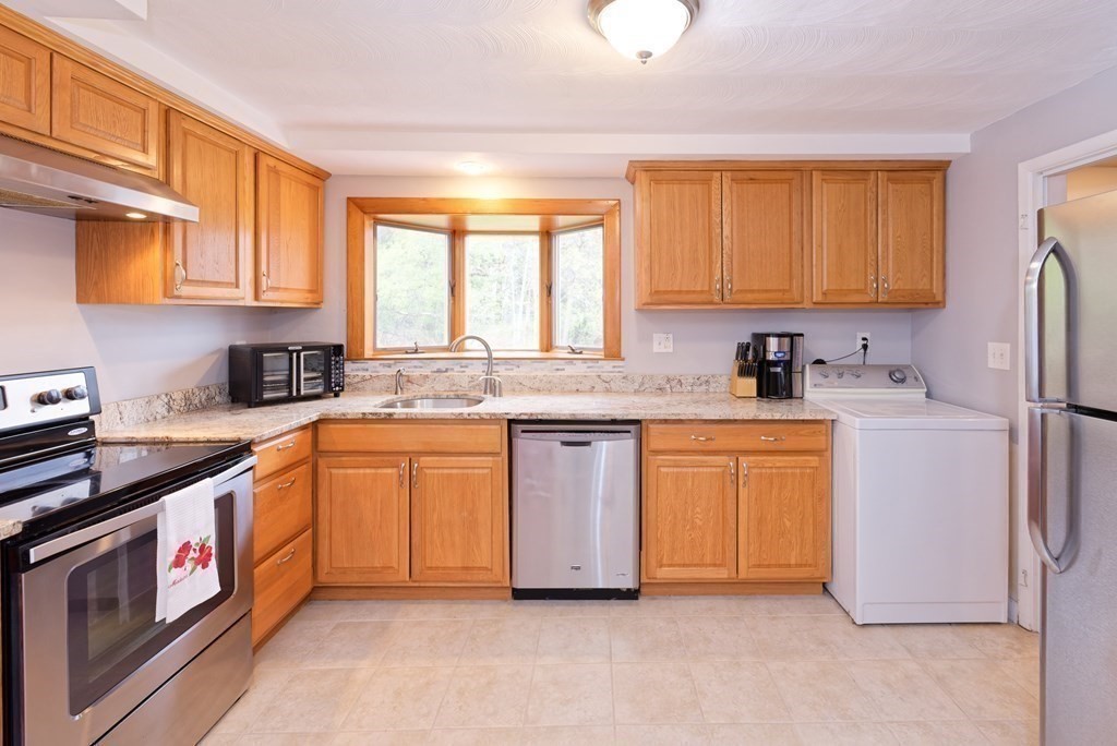 54 Gregory Road Framingham, MA 01701 - Photo 21 of 41 a kitchen with stainless steel appliances granite countertop a sink stove refrigerator and cabinets