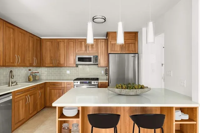 a kitchen with stainless steel appliances granite countertop a sink and a refrigerator