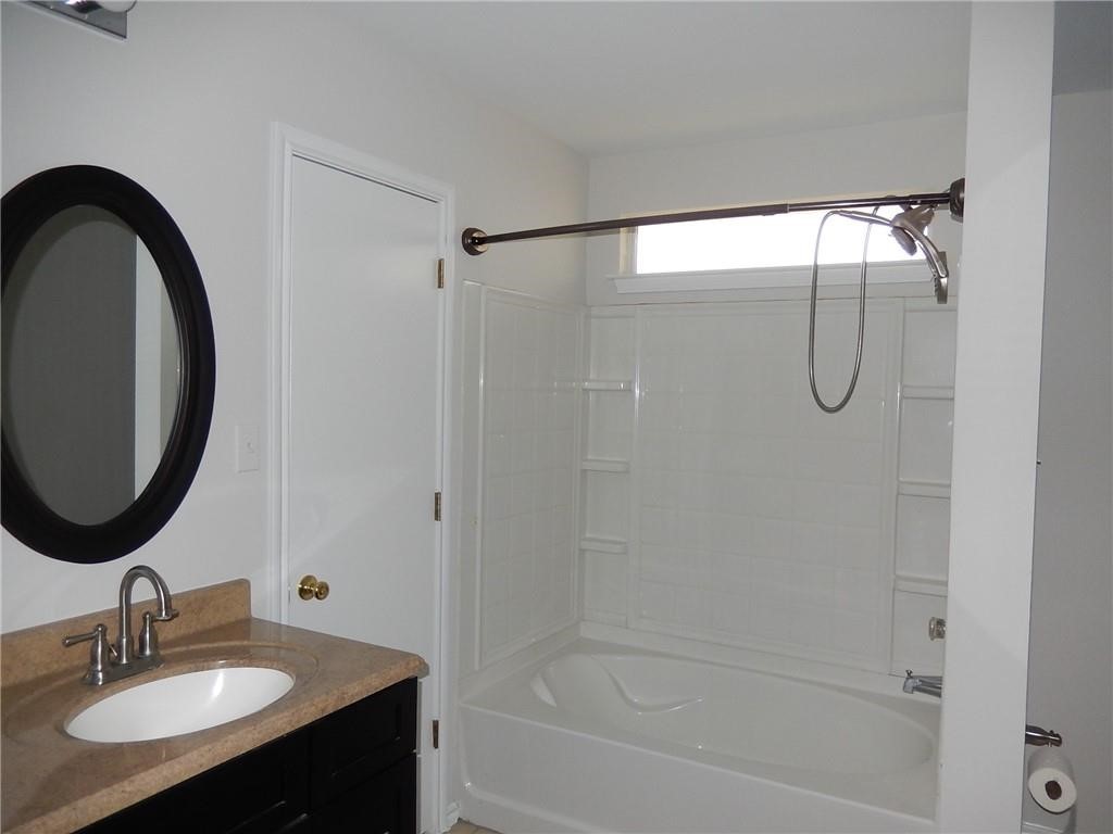 116 Rinehardt Street Hutto, TX 78634 - Photo 13 of 27 a bathroom with a granite countertop sink a mirror and shower