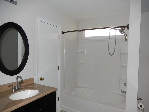 a bathroom with a granite countertop sink a mirror and shower