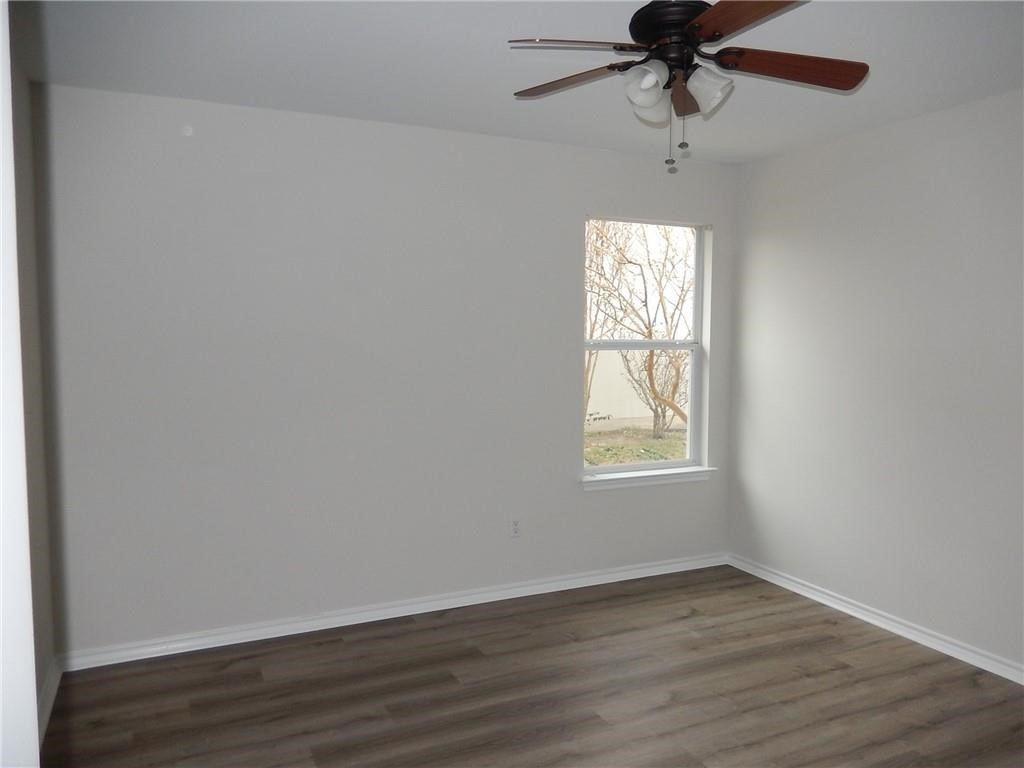 116 Rinehardt Street Hutto, TX 78634 - Photo 19 of 27 an empty room with wooden floor fan and windows