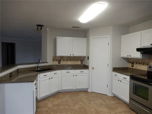 a kitchen with granite countertop a sink and a stove