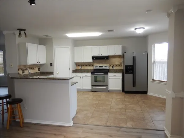 a kitchen with stainless steel appliances granite countertop a stove a sink and a refrigerator