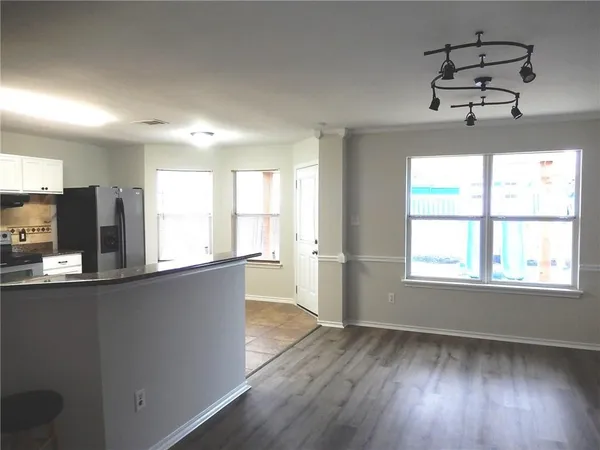 a view of a kitchen with wooden floor and windows