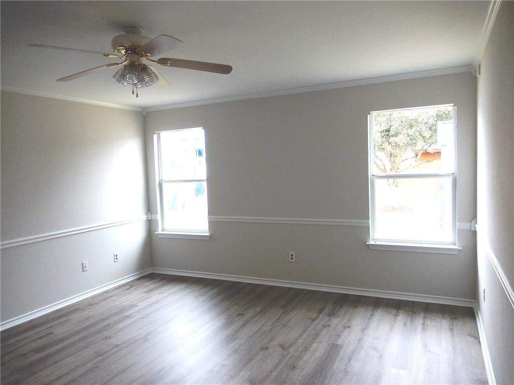 116 Rinehardt Street Hutto, TX 78634 - Photo 8 of 27 an empty room with wooden floor chandelier fan and windows