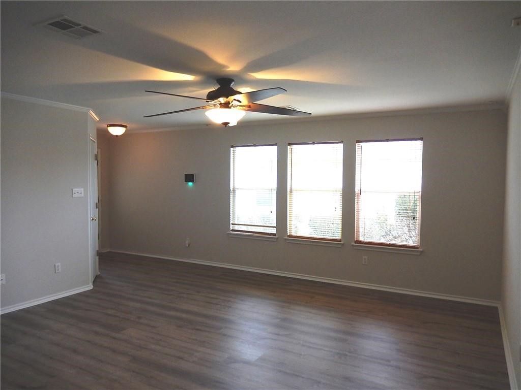 116 Rinehardt Street Hutto, TX 78634 - Photo 10 of 27 an empty room with wooden floor fan and windows