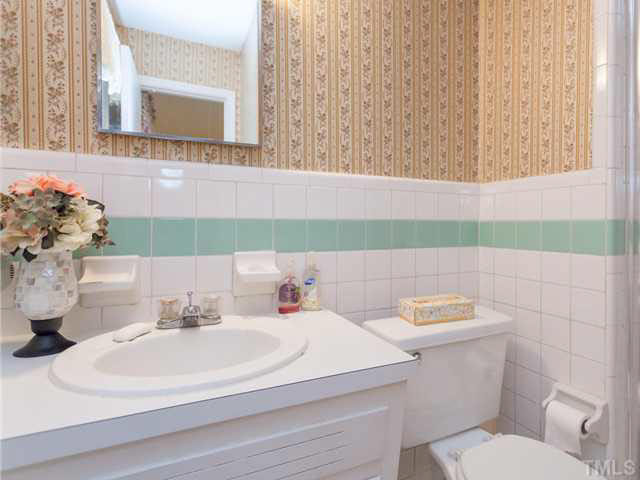3605 Donna Road Raleigh, NC 27604 - Photo 19 of 25 The master bath features a half wall of ceramic tile with an accent border and a walk in shower. Electric heat in walls.
