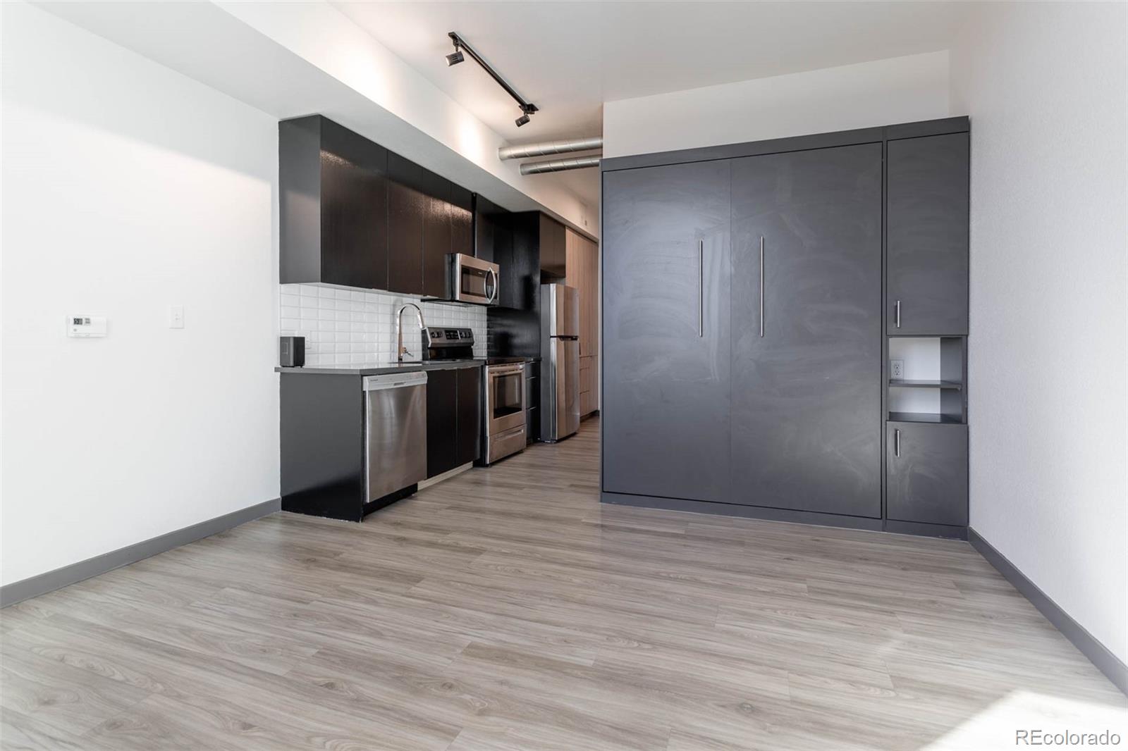 603 Inca Street, Unit 313 Denver, CO 80204 - Photo 12 of 20 a view of a kitchen with wooden floor electronic appliances and stairs