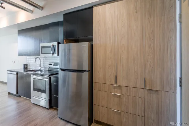a kitchen with stainless steel appliances granite countertop a refrigerator and a sink