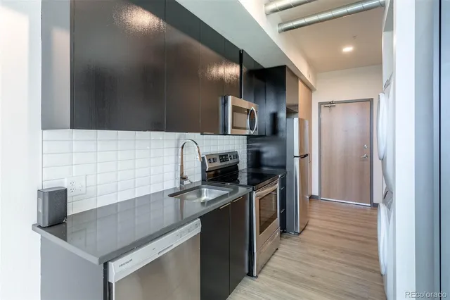 a kitchen with stainless steel appliances granite countertop a sink and a stove top oven