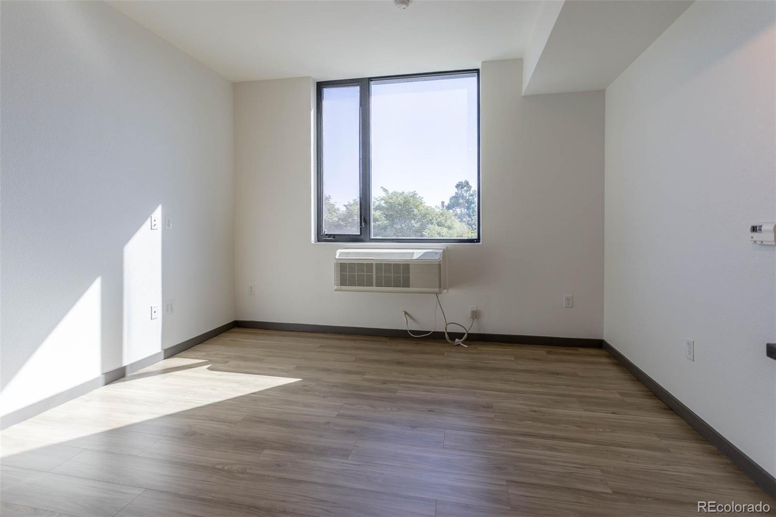 603 Inca Street, Unit 313 Denver, CO 80204 - Photo 10 of 20 an empty room with wooden floor and windows