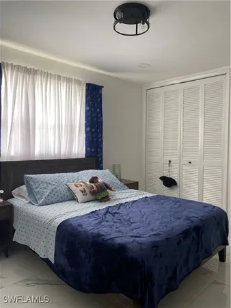 a bedroom with a bed flowerpot and window