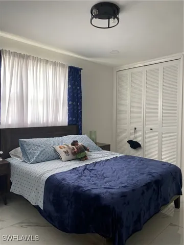 a bedroom with a bed flowerpot and window
