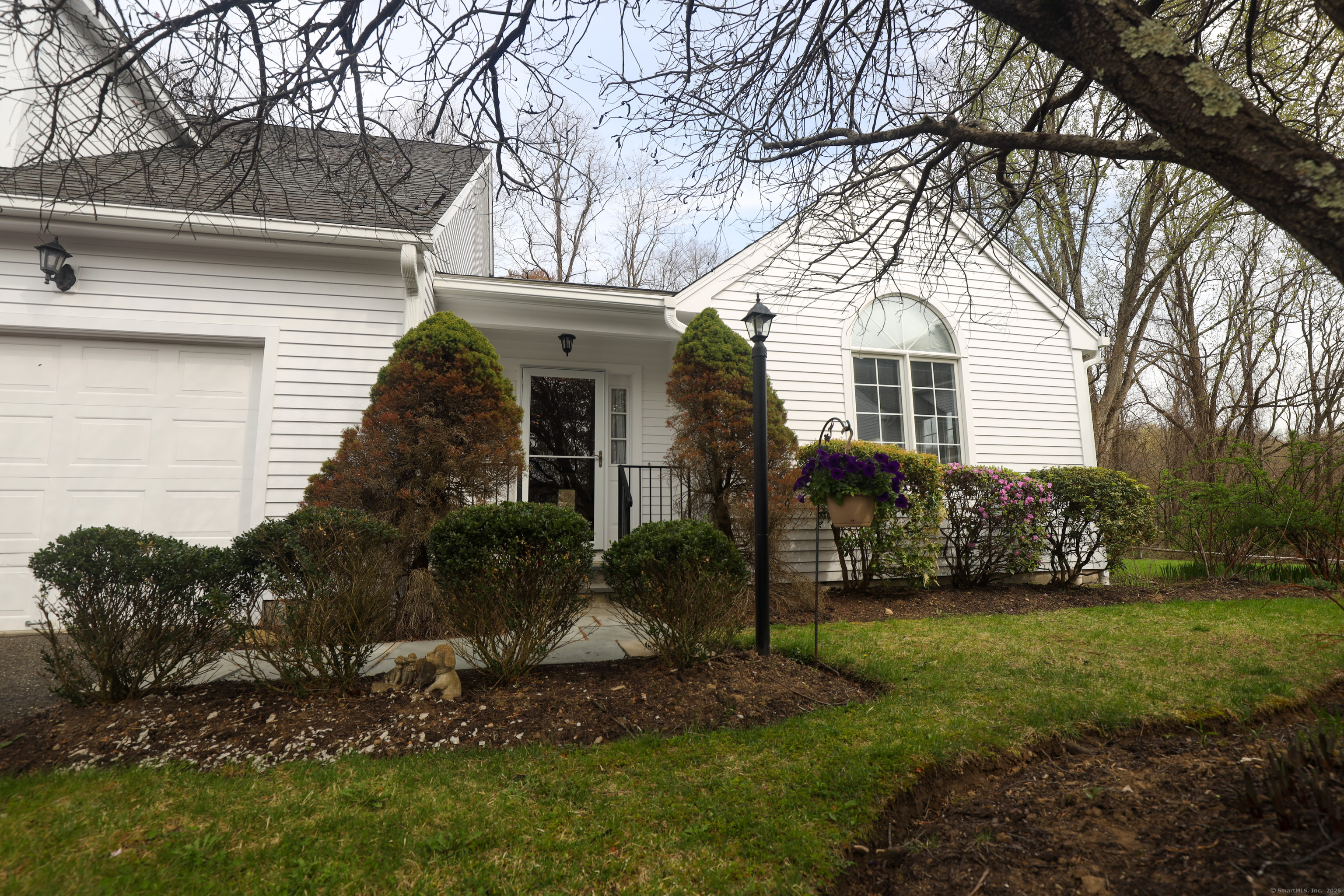 a front view of a house with a garden and yard