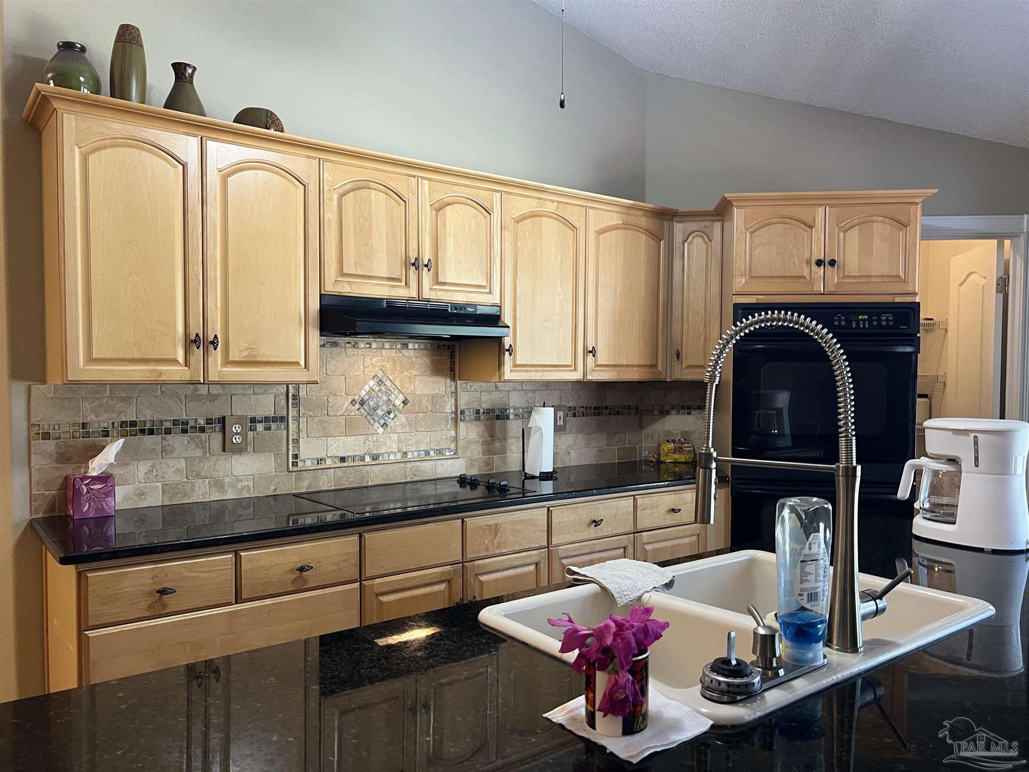 12465 Red Cloud Road Pensacola, FL 32507 - Photo 22 of 68 a kitchen with granite countertop a sink a stove and cabinets
