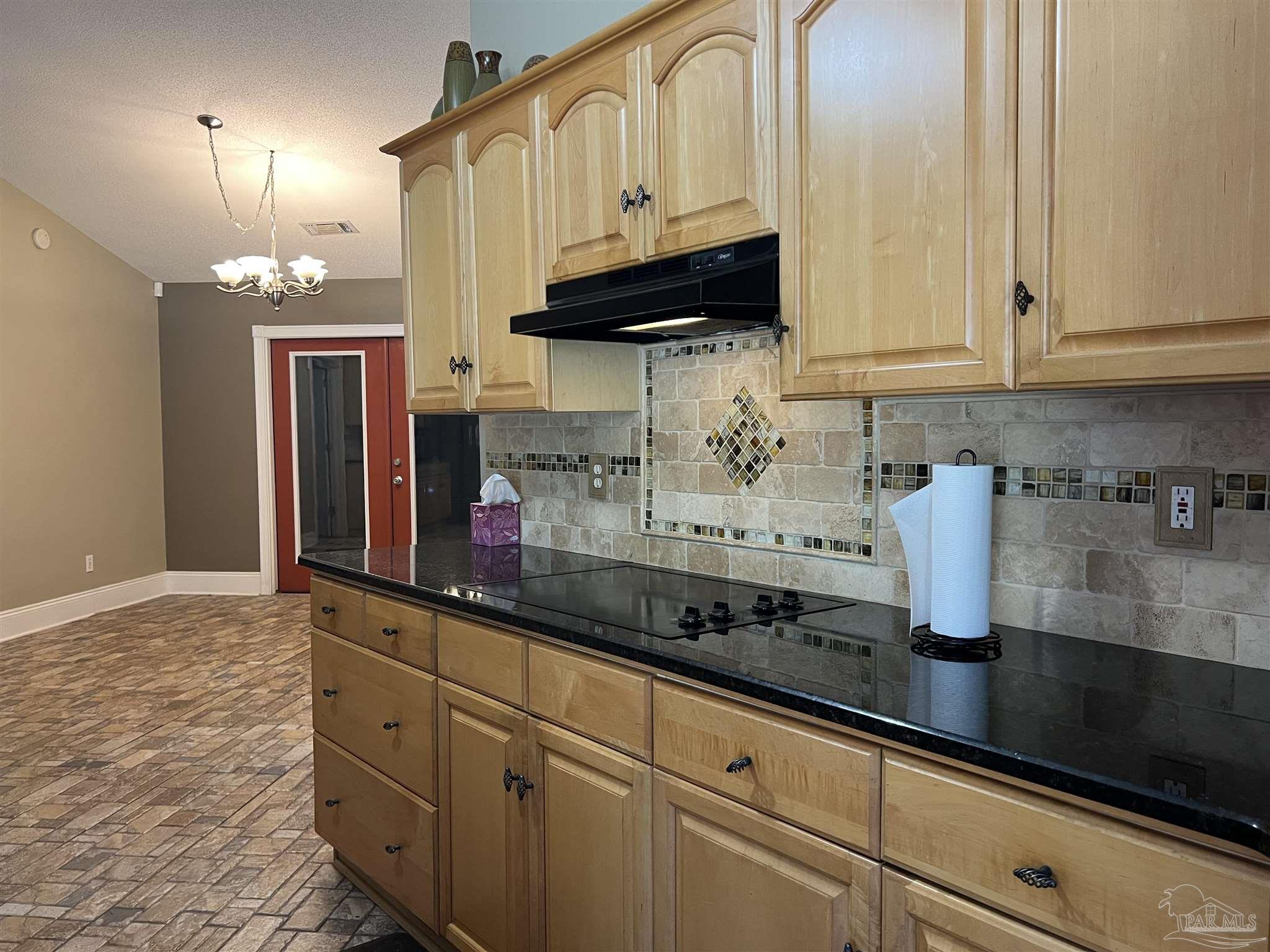 12465 Red Cloud Road Pensacola, FL 32507 - Photo 23 of 68 a kitchen with granite countertop a sink a stove and cabinets