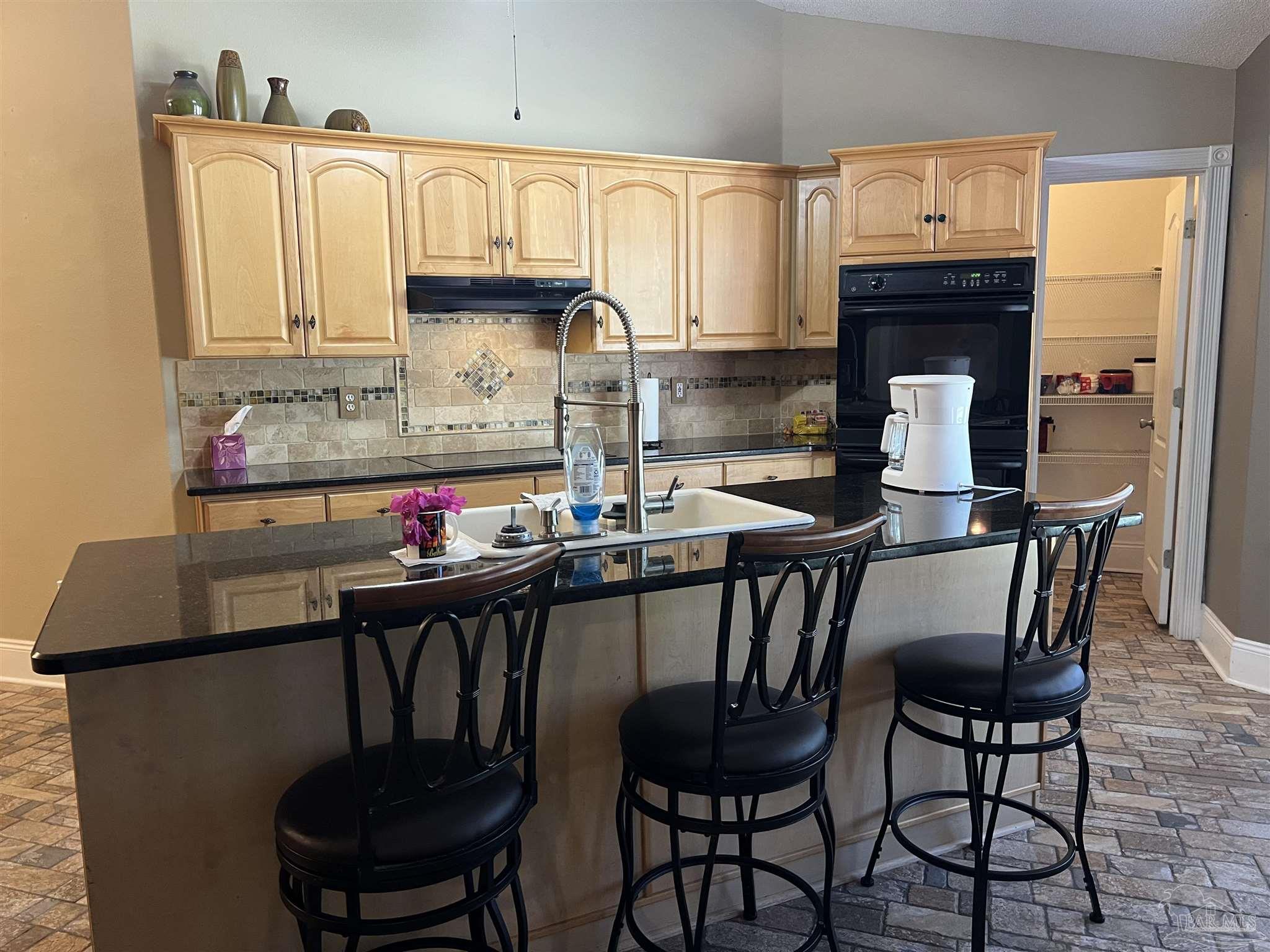 12465 Red Cloud Road Pensacola, FL 32507 - Photo 32 of 68 a kitchen with granite countertop a dining table chairs and a refrigerator