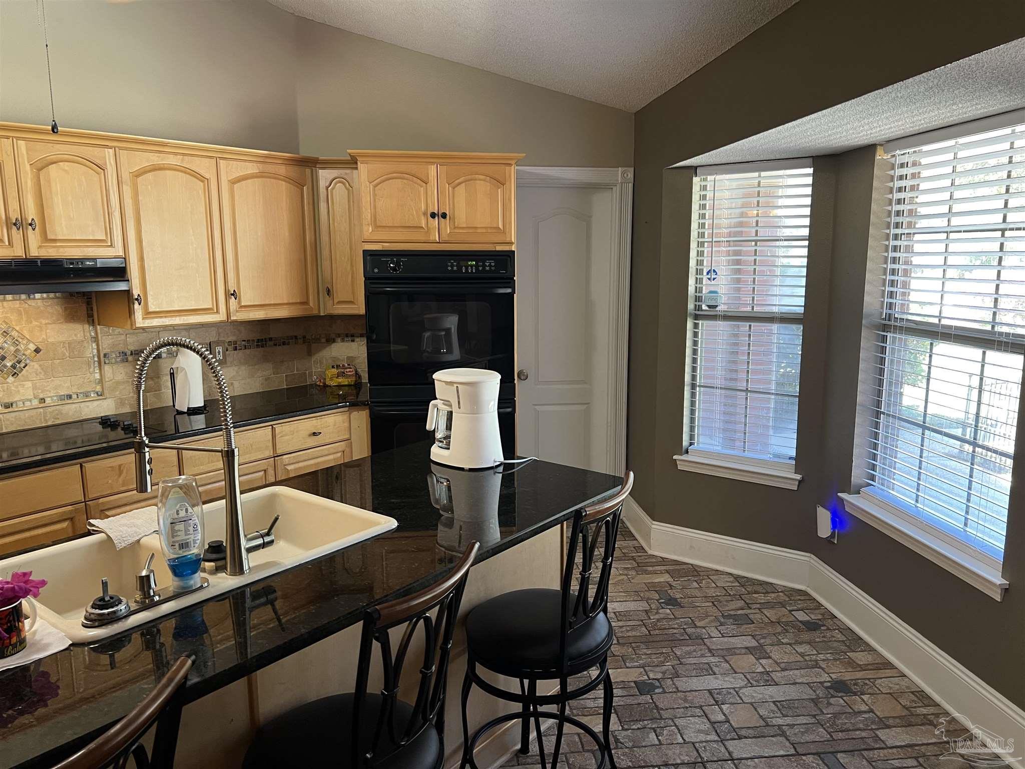 12465 Red Cloud Road Pensacola, FL 32507 - Photo 33 of 68 a kitchen with a table chairs sink and cabinets