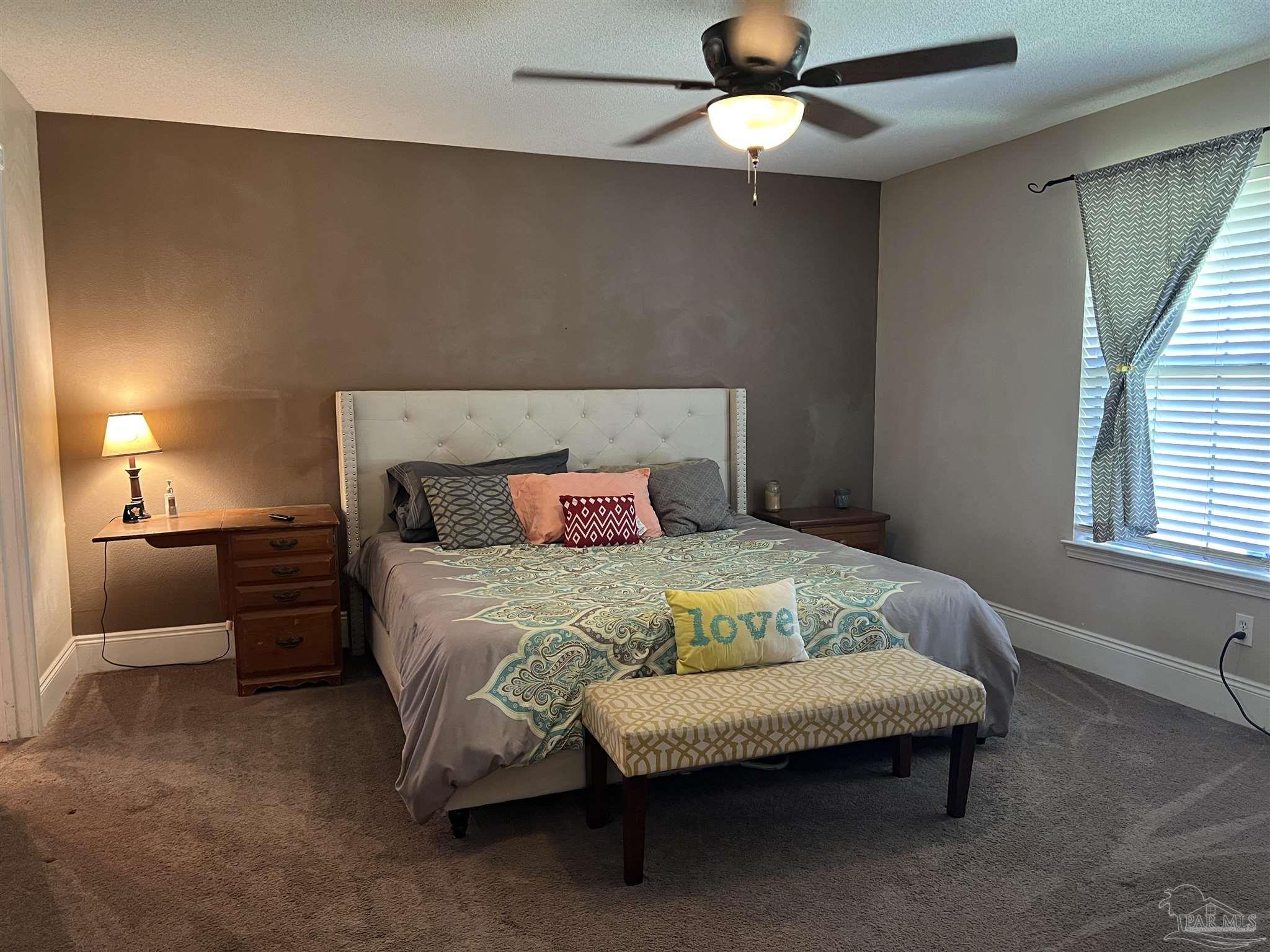 12465 Red Cloud Road Pensacola, FL 32507 - Photo 35 of 68 a bedroom with a bed and a chandelier