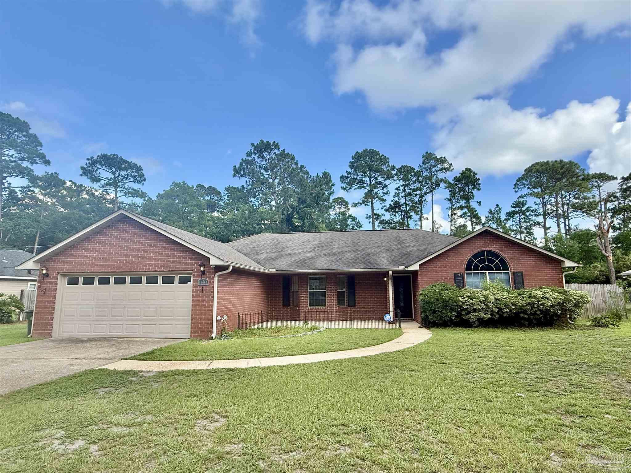 12465 Red Cloud Road Pensacola, FL 32507 - Photo 68 of 68 a front view of a house with a yard and garage