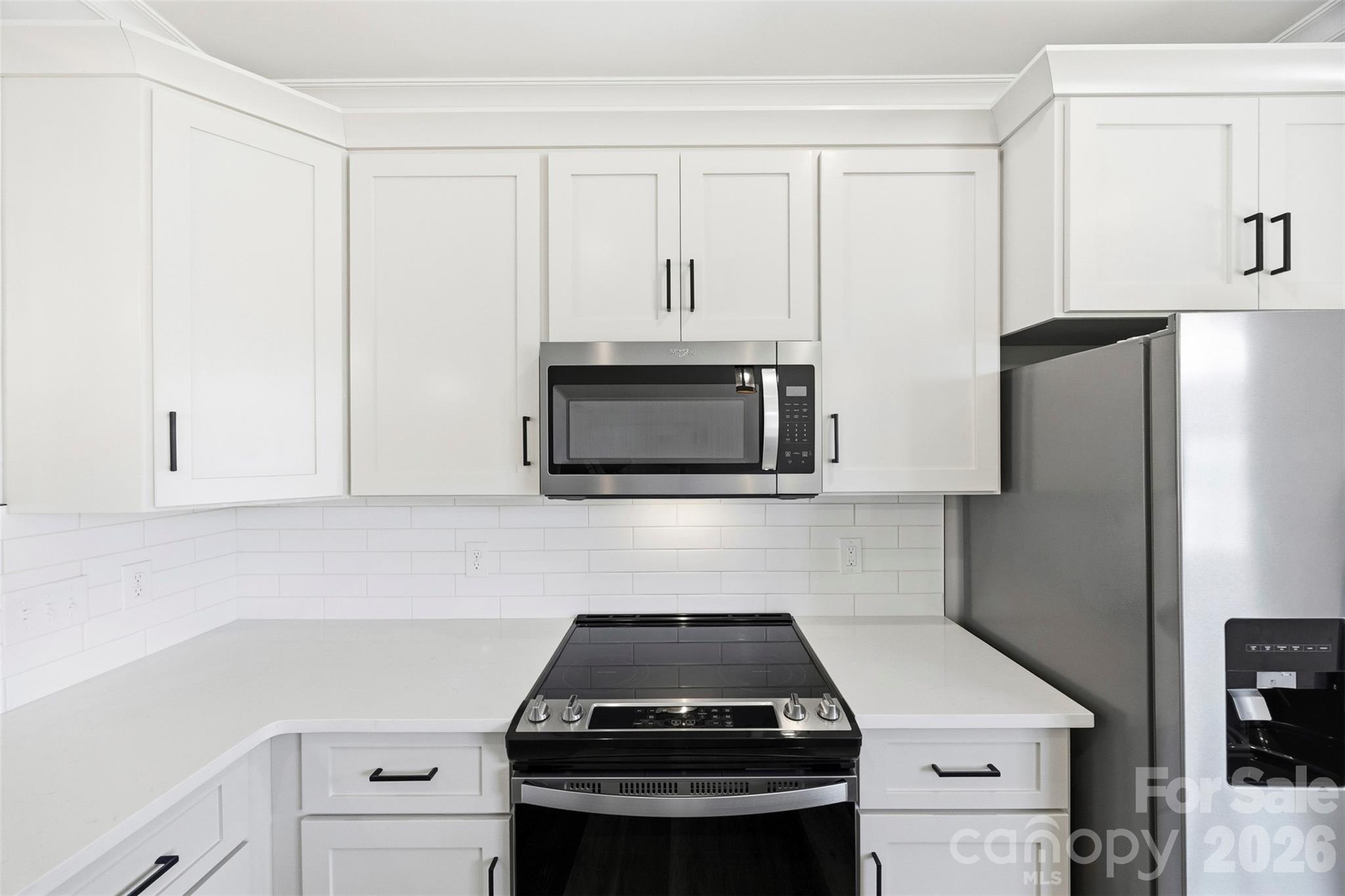 1014 Speight Road Albemarle, NC 28001 - Photo 13 of 28 a kitchen with white cabinets and stainless steel appliances