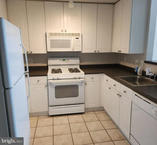 a kitchen with white cabinets and white appliances