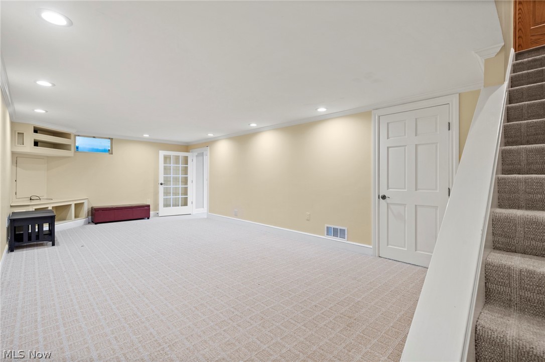 3871 Greentree Road Stow, OH 44224 - Photo 32 of 50 Spacious carpeted finished basement featuring recessed lighting, built-in shelving, a glass-paned door, a solid panel door, and a carpeted staircase