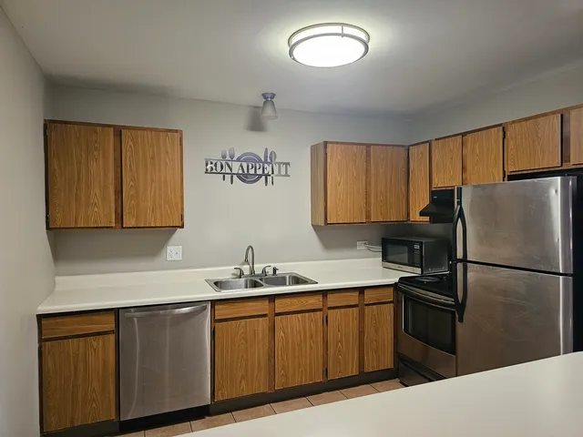 a kitchen with a sink a refrigerator and cabinets