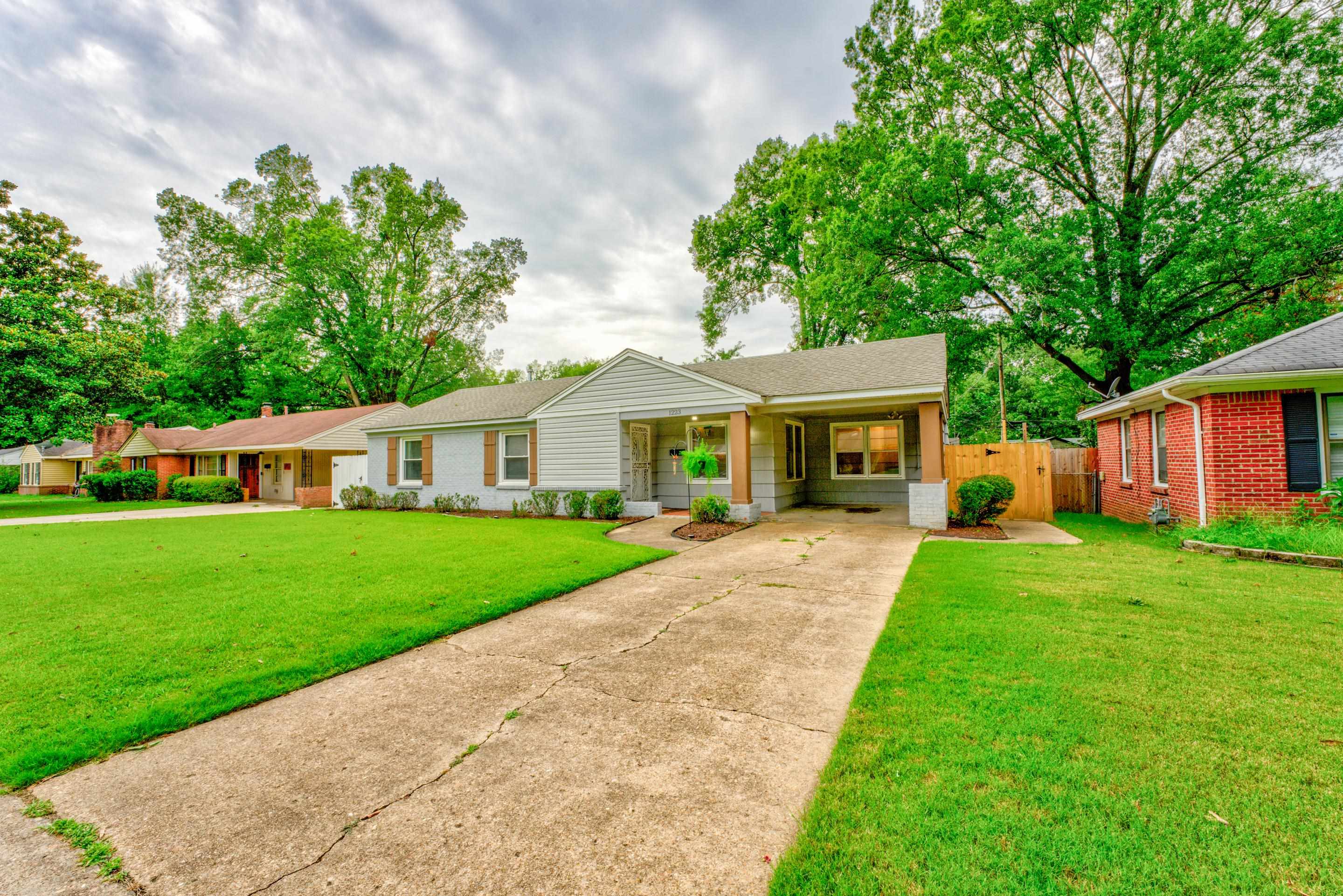 1223 Dearing Road Memphis, TN 38117 - Photo 3 of 34 a front view of a house with a garden and trees