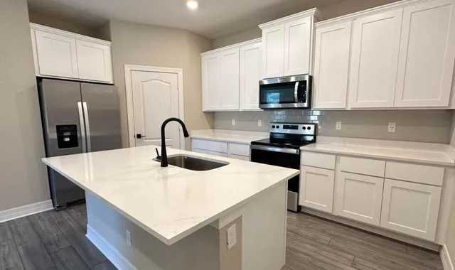 a kitchen with stainless steel appliances granite countertop a white stove top oven and refrigerator