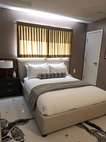 a bedroom with a bed and a window