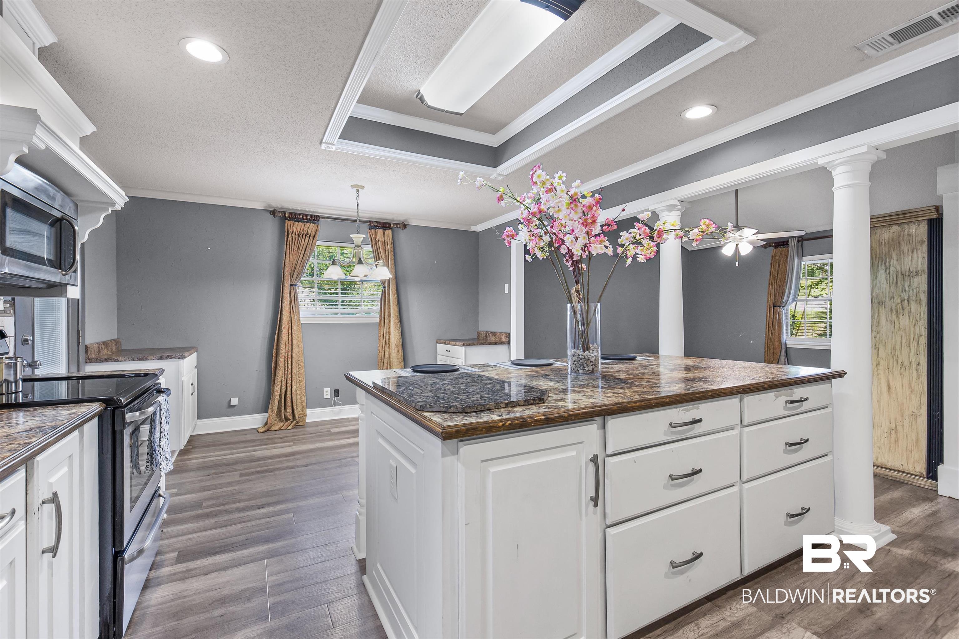 36 Ridgeview Drive Mobile, AL 36611 - Photo 3 of 20 Kitchen featuring white cabinets, crown molding, appliances with stainless steel finishes, a tray ceiling, and a center island
