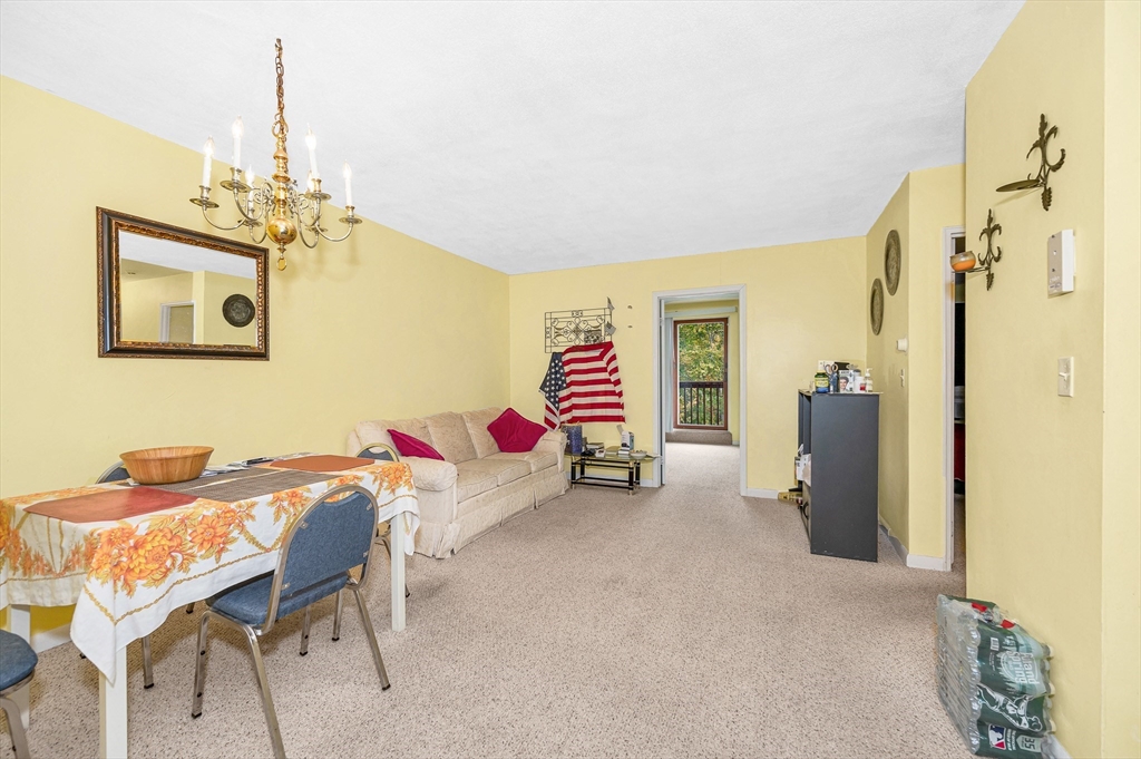 110 Boston Post Road East, Unit 104 Marlborough, MA 01752 - Photo 3 of 25 a living room with furniture and a chandelier