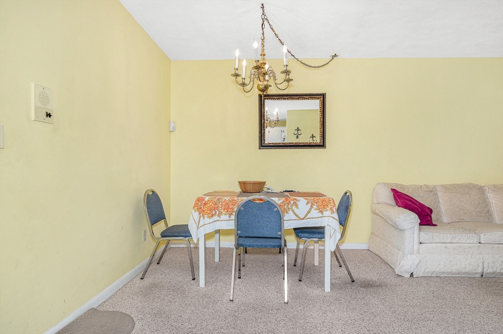 110 Boston Post Road East, Unit 104 Marlborough, MA 01752 - Photo 4 of 25 a view of a dining room with furniture and chandelier