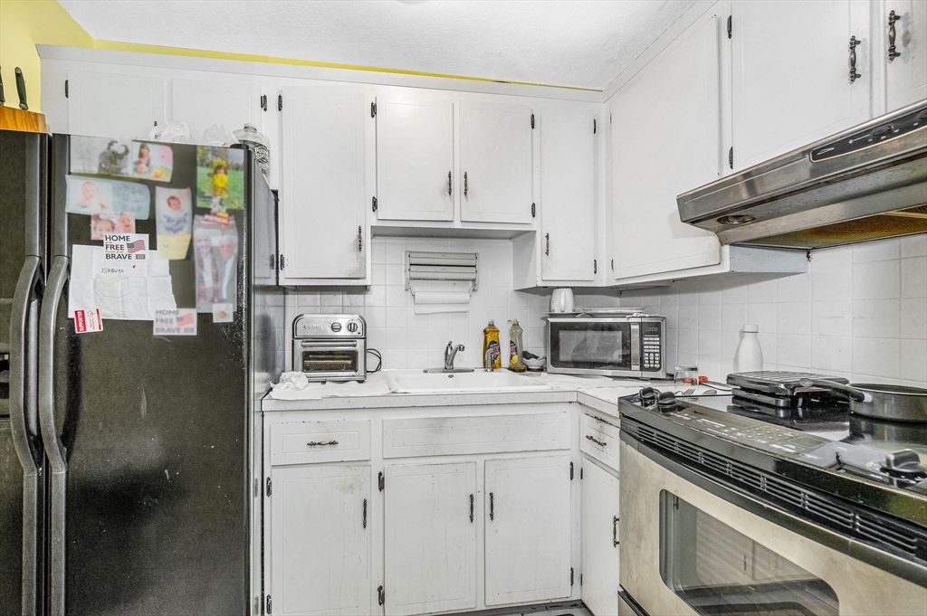 110 Boston Post Road East, Unit 104 Marlborough, MA 01752 - Photo 8 of 25 a kitchen with stainless steel appliances a sink stove and refrigerator