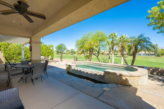a swimming pool with outdoor seating and yard