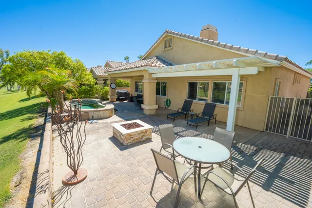 a view of a patio with table and chairs potted plants with wooden floor and fence