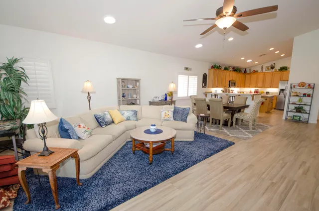 a living room with furniture and a dining table with wooden floor