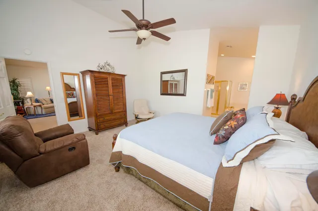 a bedroom with a bed a ceiling fan and a dresser