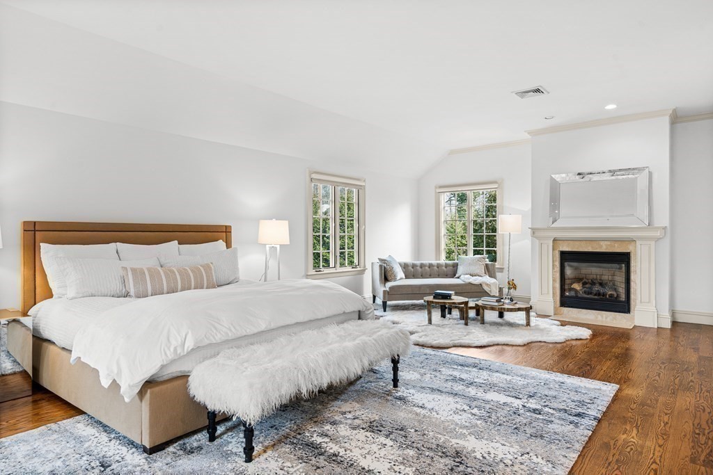 77 Cliff Road Wellesley, MA 02481 - Photo 21 of 33 a bedroom with a bed a table and a fireplace